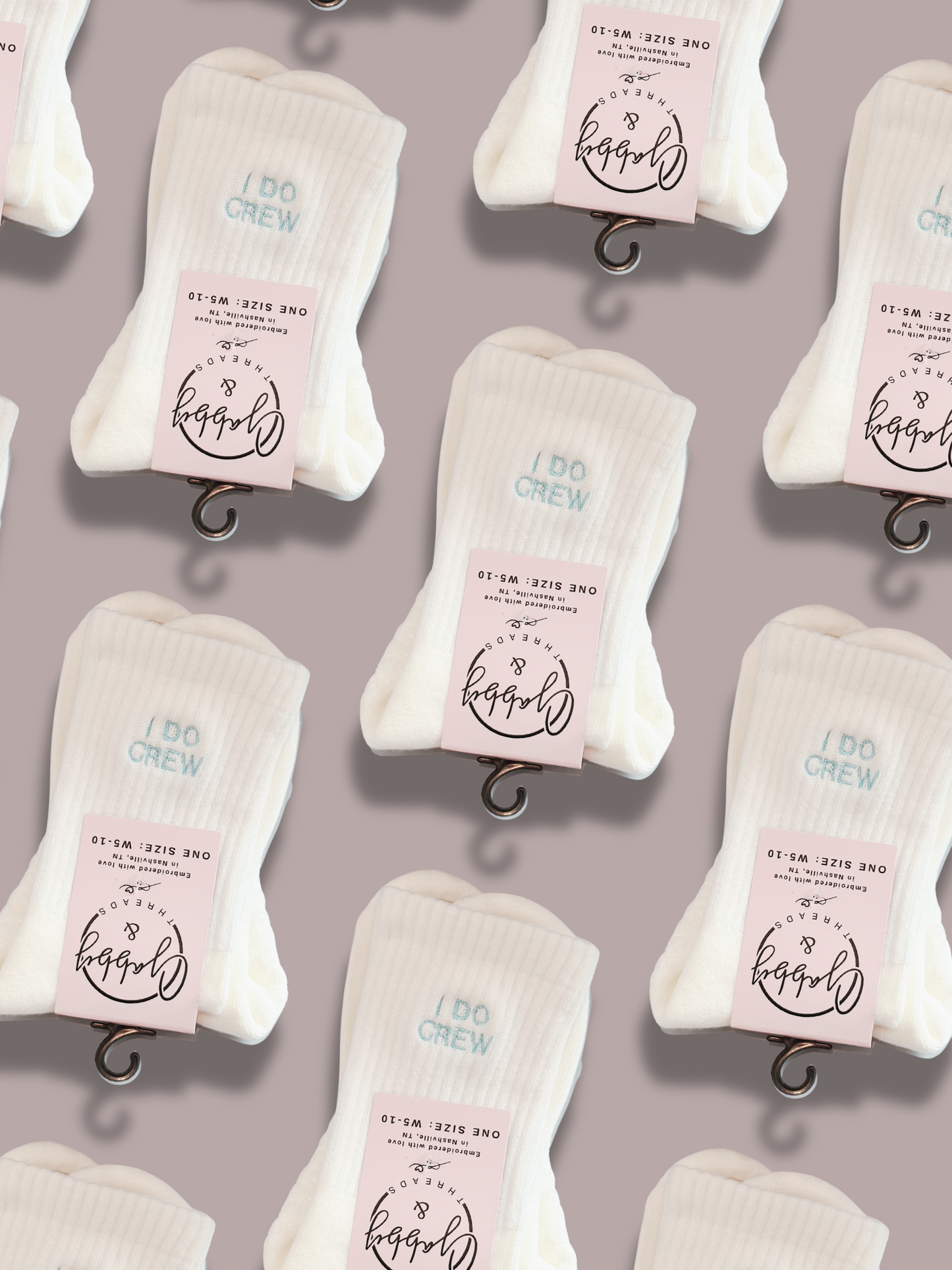 White socks with 'I Do Crew' embroidered on them on a gray background