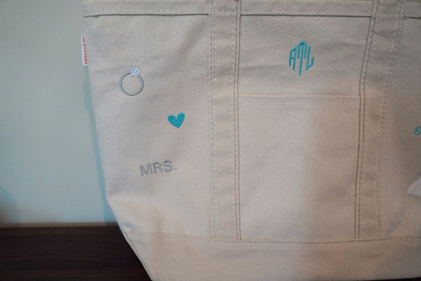 Beige bag with teal text and wedding/bridal icons
