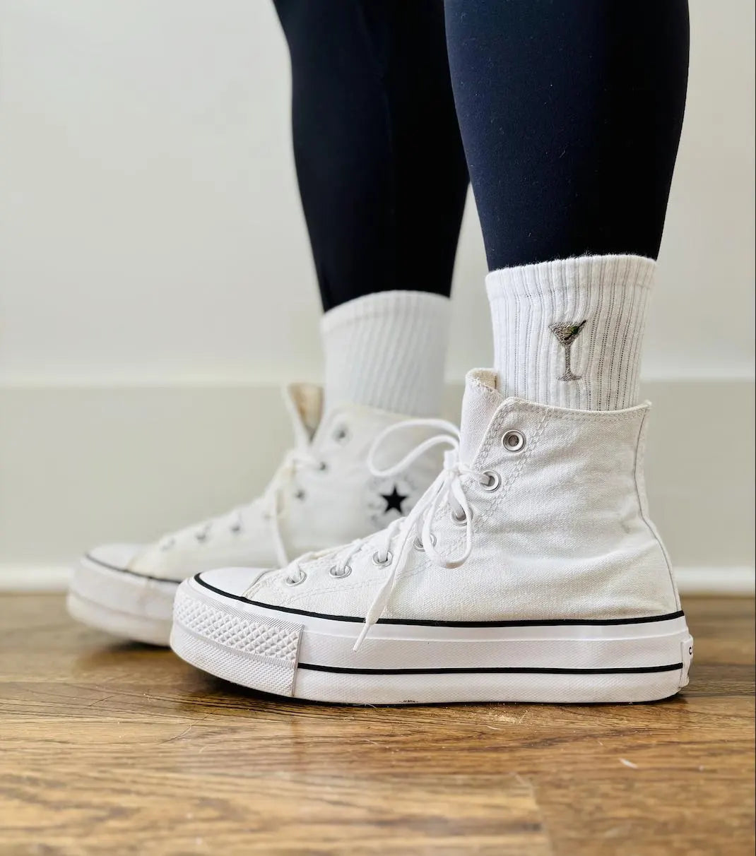 a person is wearing converse and embroidered crew socks with dirty martini socks
