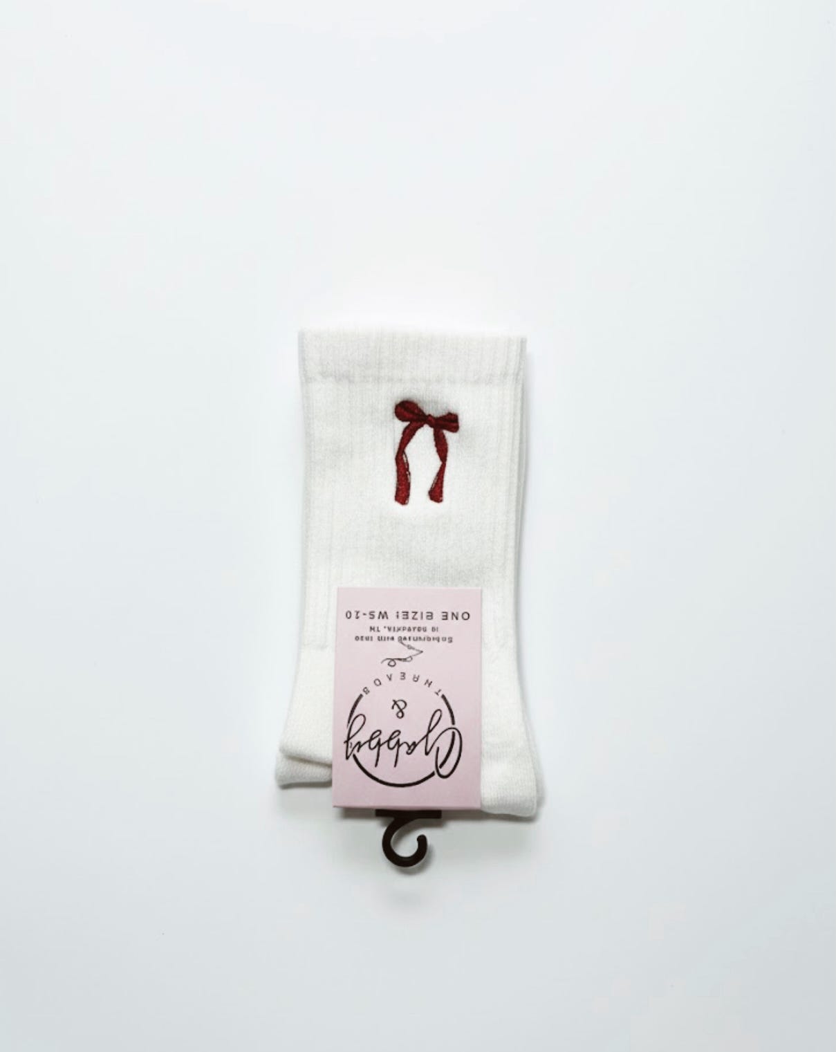 a pair of white grip socks with an embroidered red coquette bow