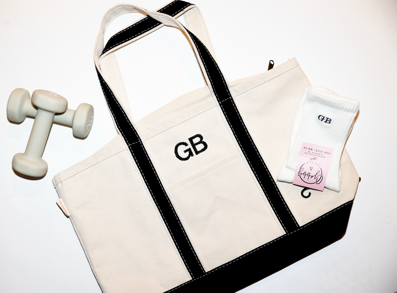 Custom embroidered beige tote bag with green accents and the initials "GB".