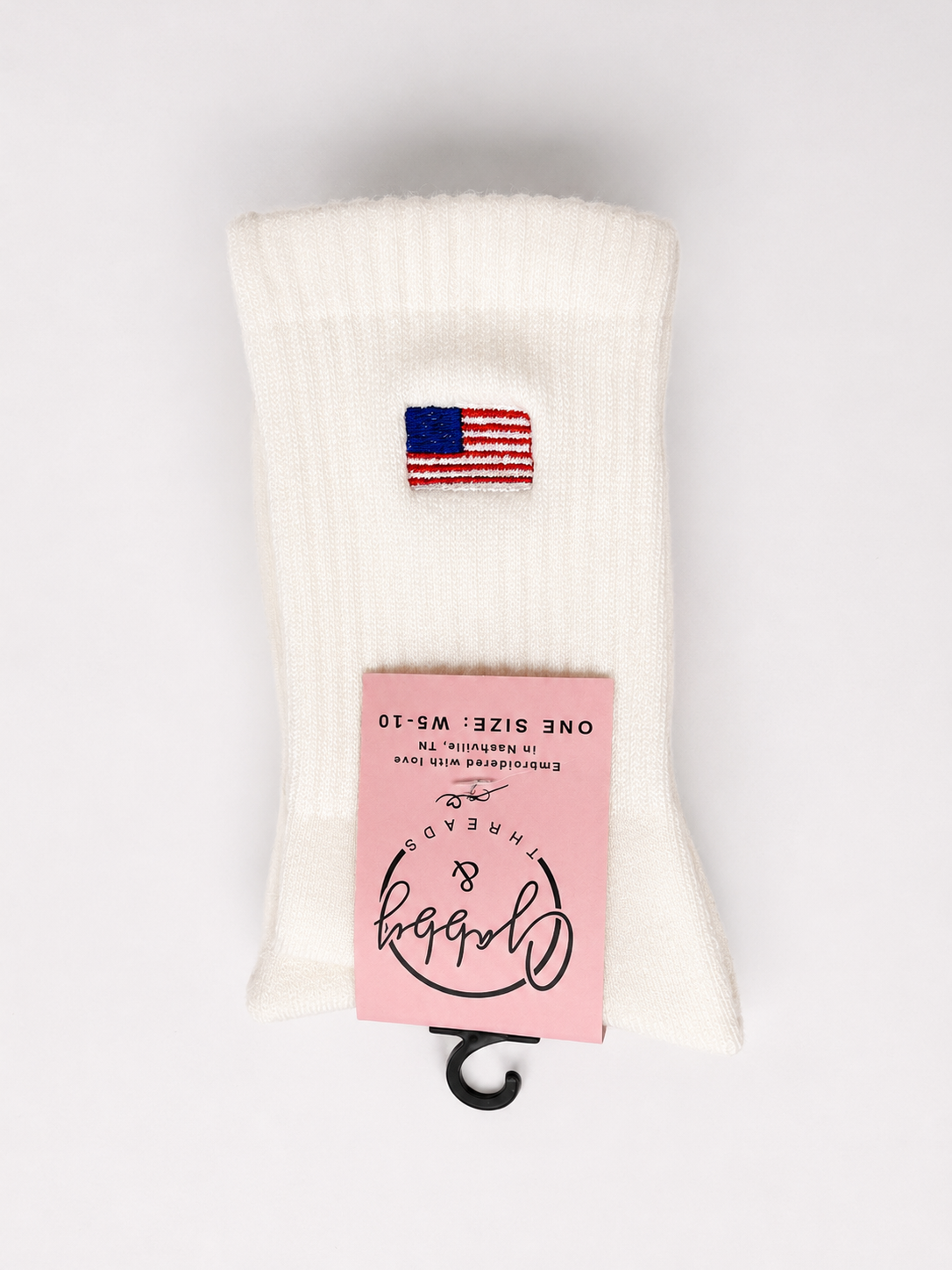 White sock with American flag design and pink label on a white background