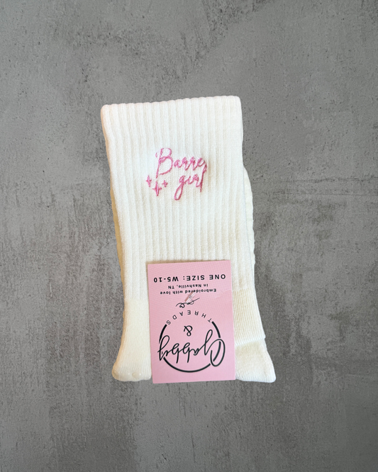 a pair of white grip socks with the words "Barre girl" embroidered on them