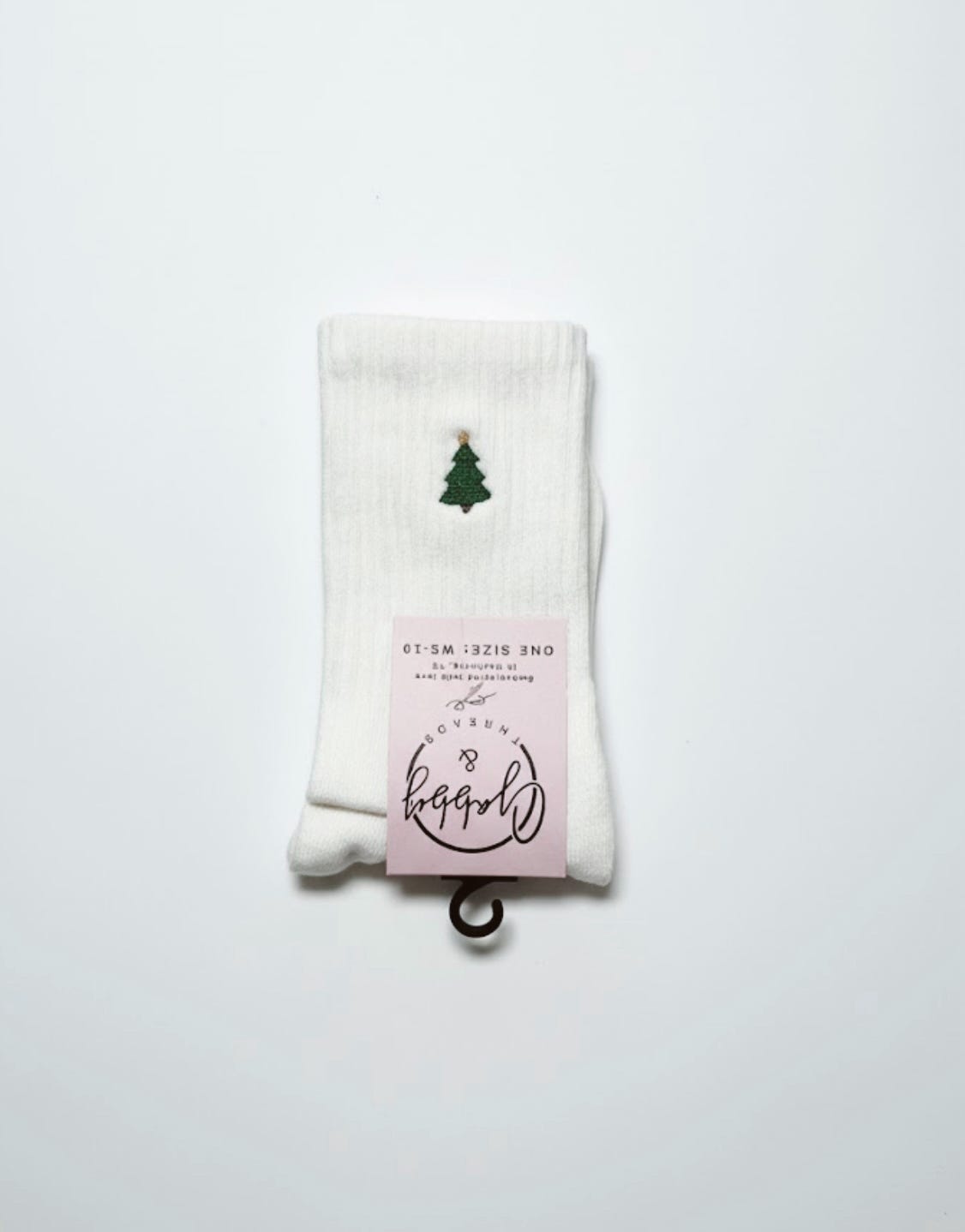 a pair of white grip socks with an embroidered christmas tree 