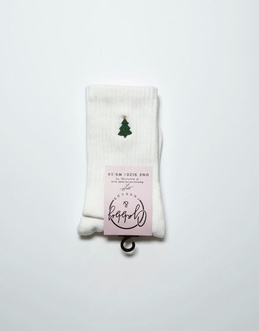 a pair of white grip socks with an embroidered christmas tree 