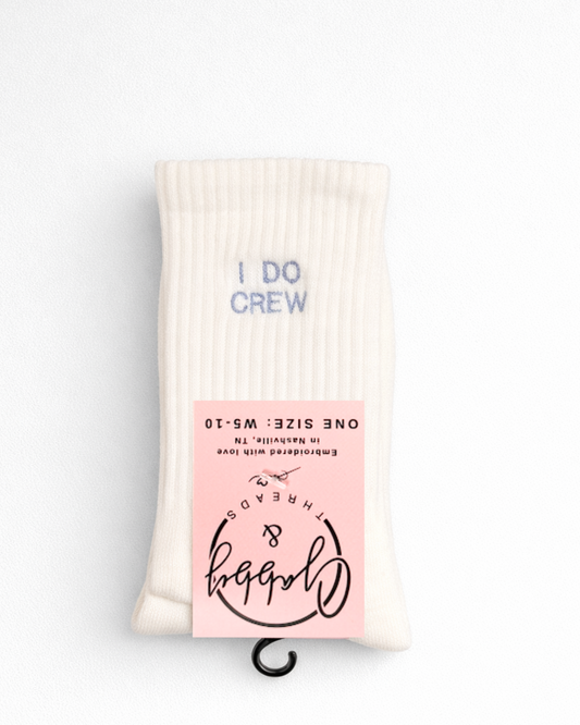 a pair of white grip socks with the words "I Do Crew" embroidered on them