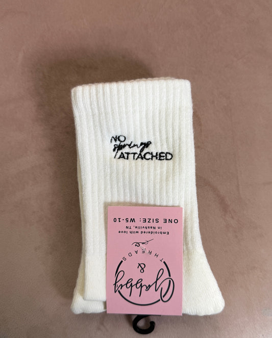White grip socks with the words "No Springs Attached" embroidered on them