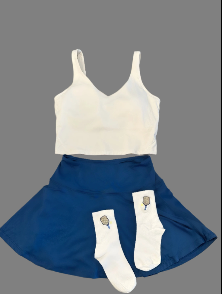 White tank top, blue skirt, and white socks with pickleball racket design on a gray background