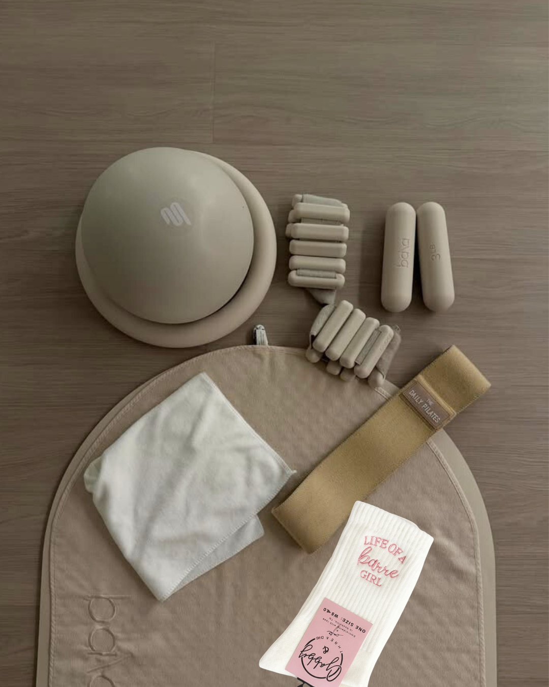 collection of workout equipment with a pair of grip socsk that say "life of a barre girl" 