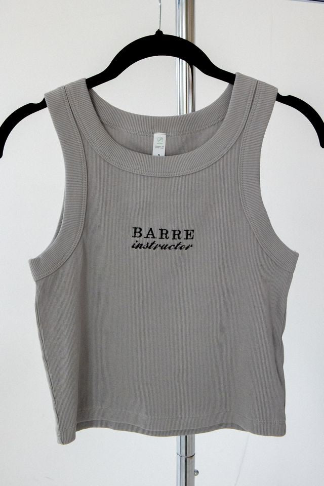 a cropped tank with the words barre instructor embroidered on it