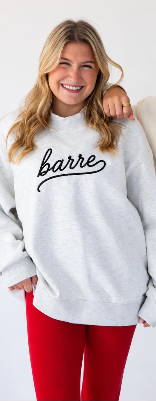 a model is wearing a heather gray mock neck sweatshirt with the word barre" embroidered on it in script font