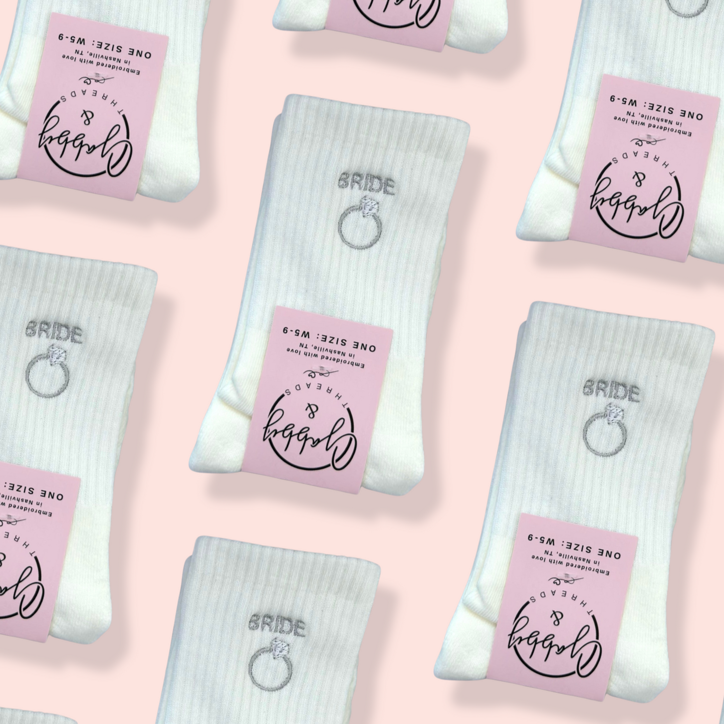 Pattern of white bride themed socks with pink labels on a pink background