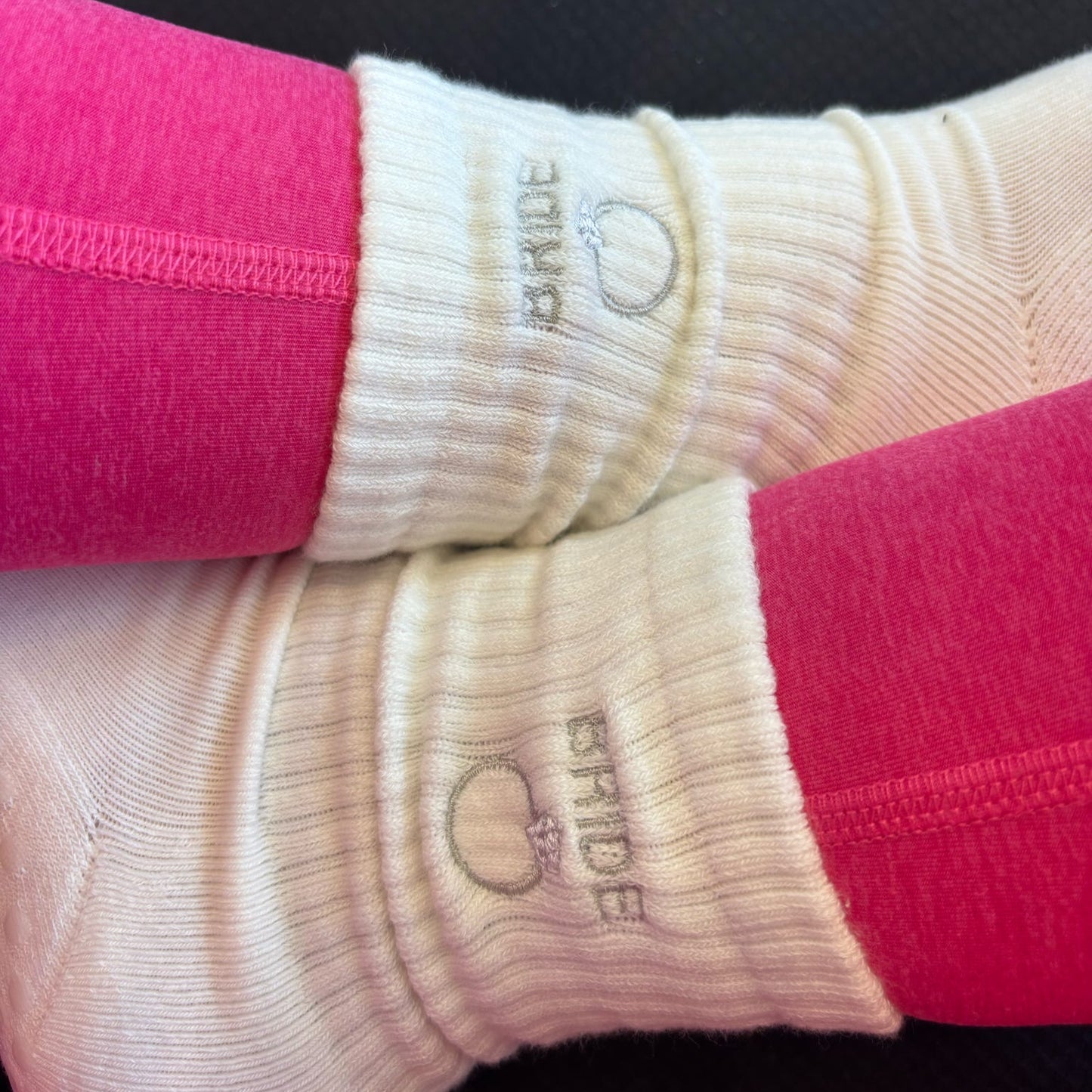 A close up of a woman wearing white grip socks with "BRIDE" embroidered and a ring