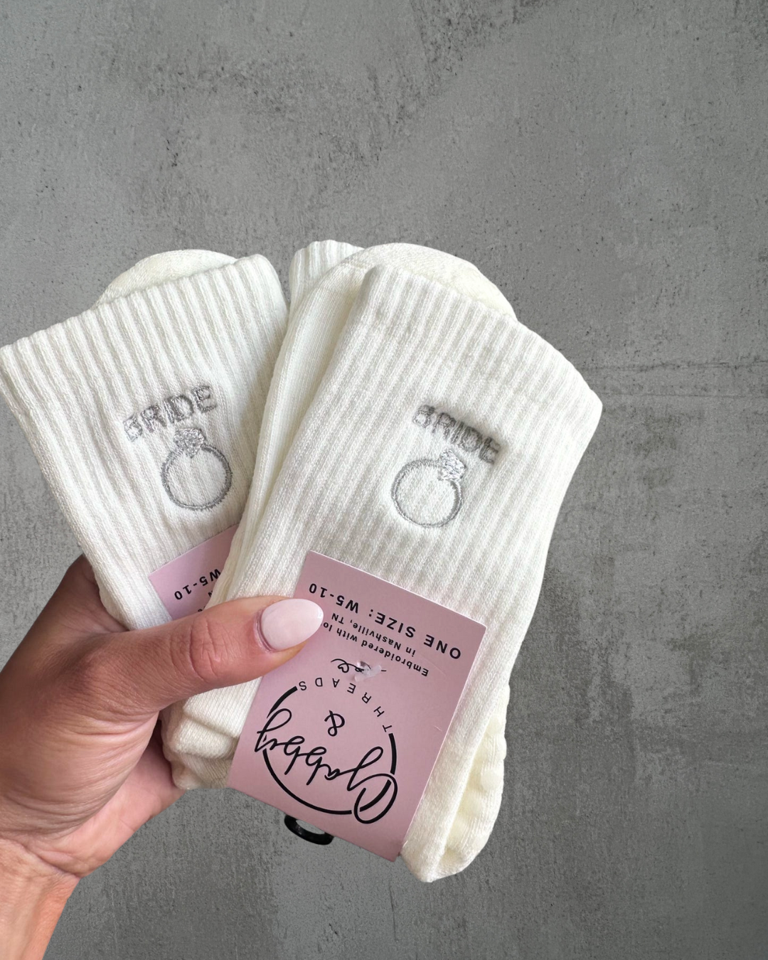 White grip socks with 'bride' and ring design against a gray background