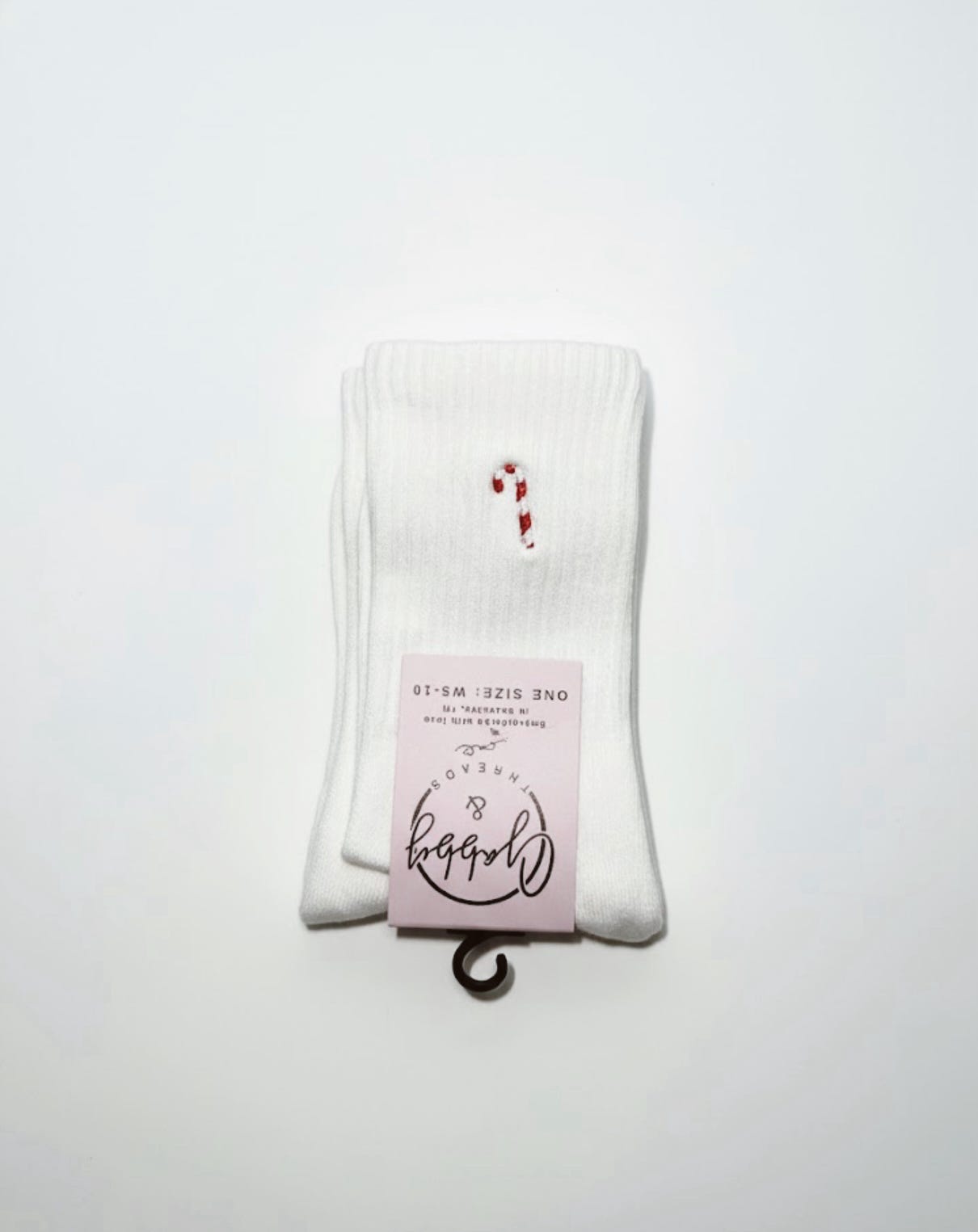 a pair of white grip socks with an embroidered candy cane on them 