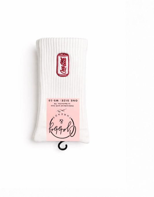 a pair of white crew socks with an embroidered coca cola can on them