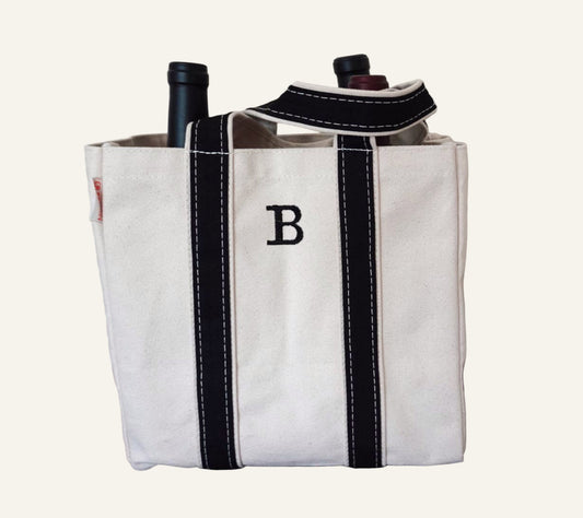 White wine tote bag with black straps and a letter 'B'