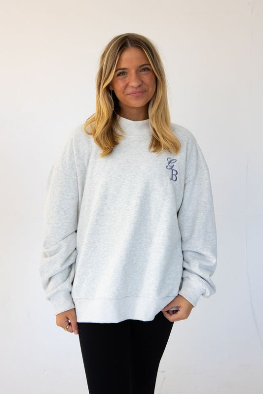 a model is wearing a custom embroidered mock neck sweatshirt with her initials 