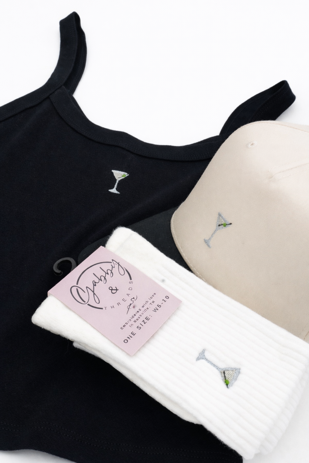 Black and beige tank tops with martini glass embroidery on a white background