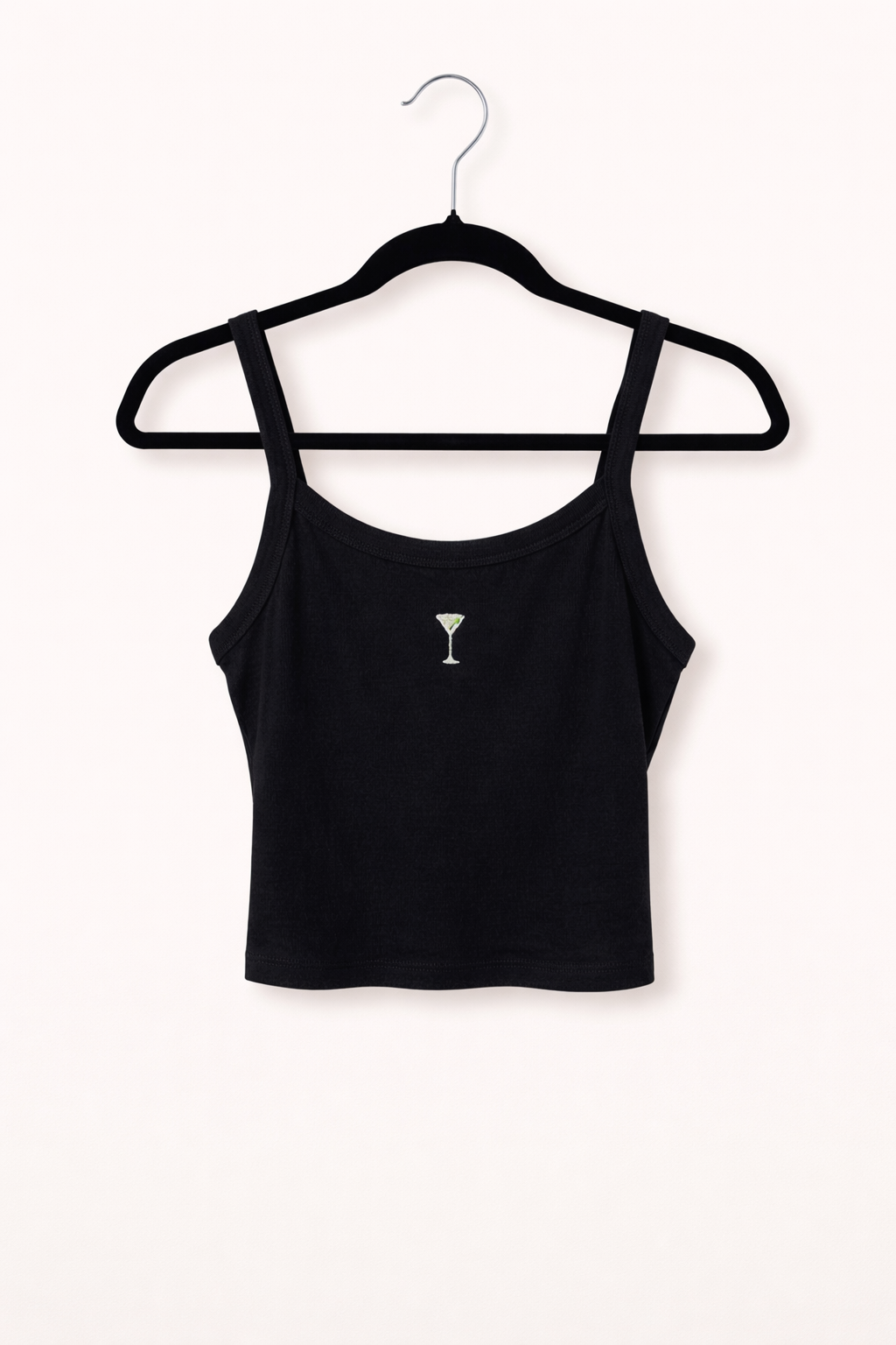 Black crop top with a small dirty martini on a hanger against a white background