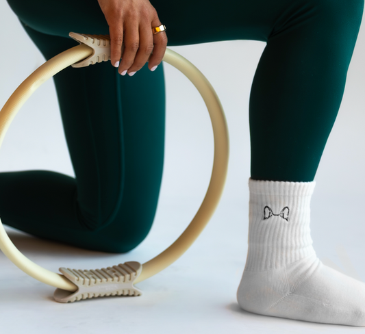 a person is wearing a pair of white grip socks with embroidered dog ears 