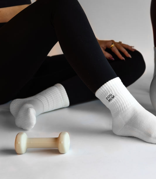 a person is wearing black leggings with white crew socks with the words dog mom embroidered on them