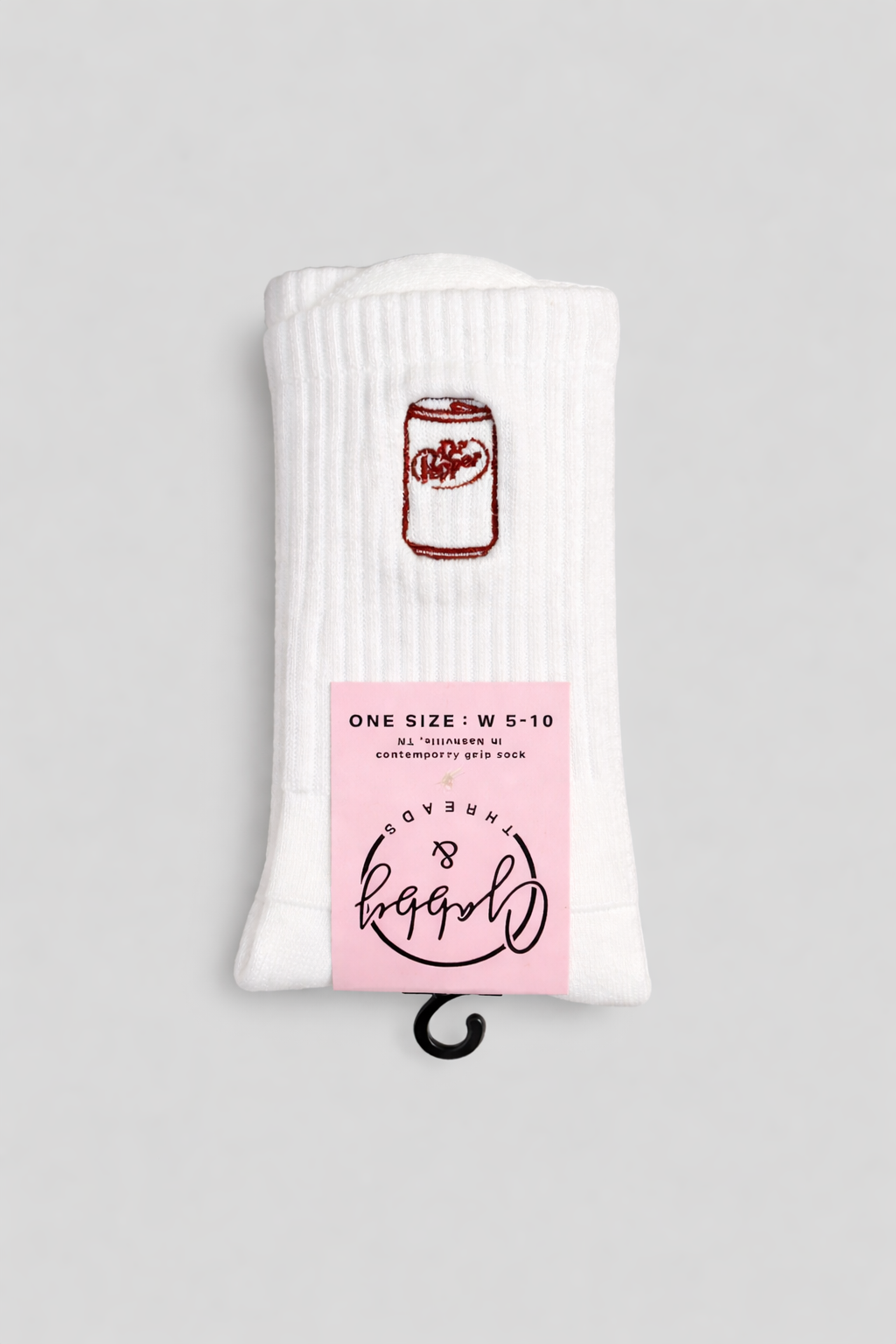 a pair of white grip socks with an embroidered dr. pepper can
