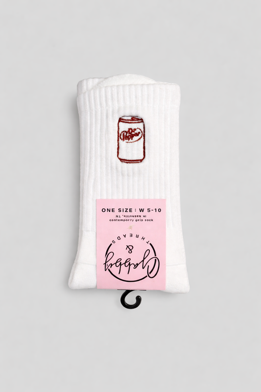 a pair of white grip socks with an embroidered dr. pepper can