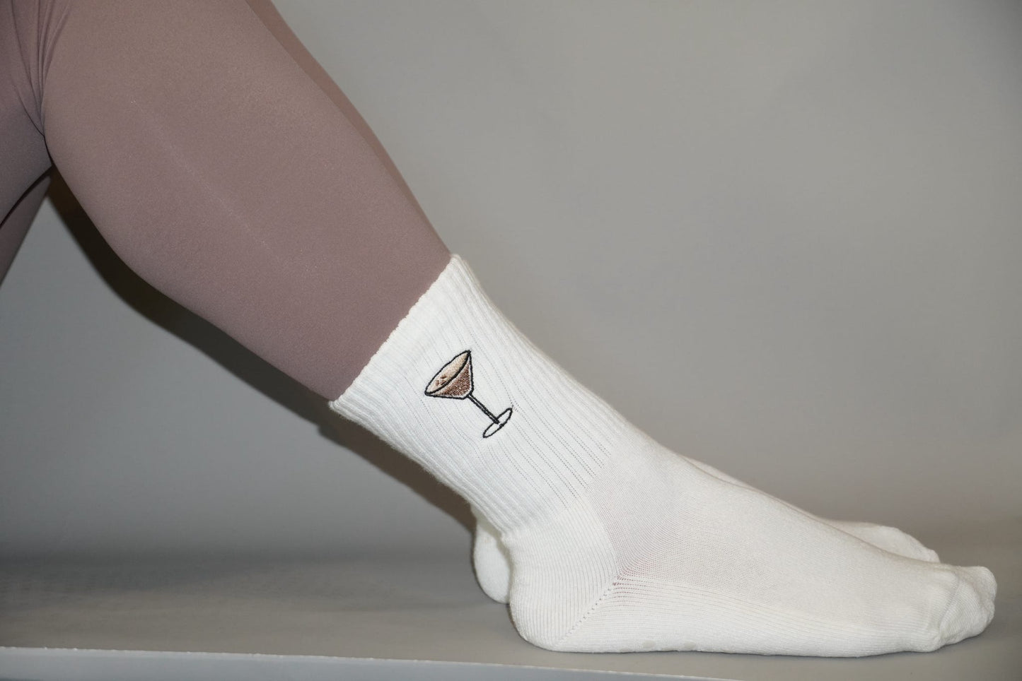 White grip socks with espresso martini design on a neutral background