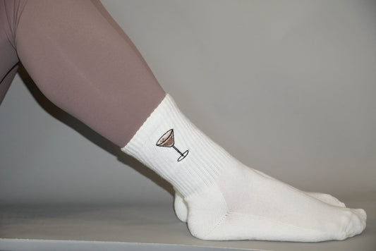 White grip socks with espresso martini design on a neutral background