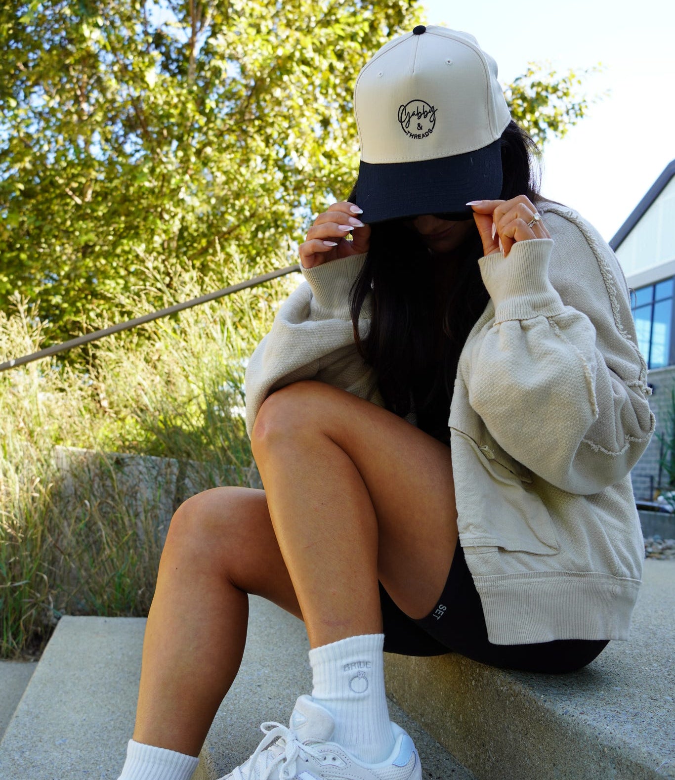 Gabby wearing a custom embroidered hat and embroidered crew socks.