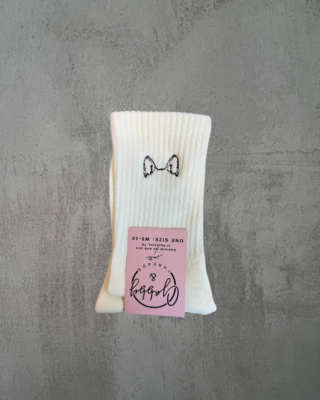 a pair of white grip socks with german shepard ears embroidered on them