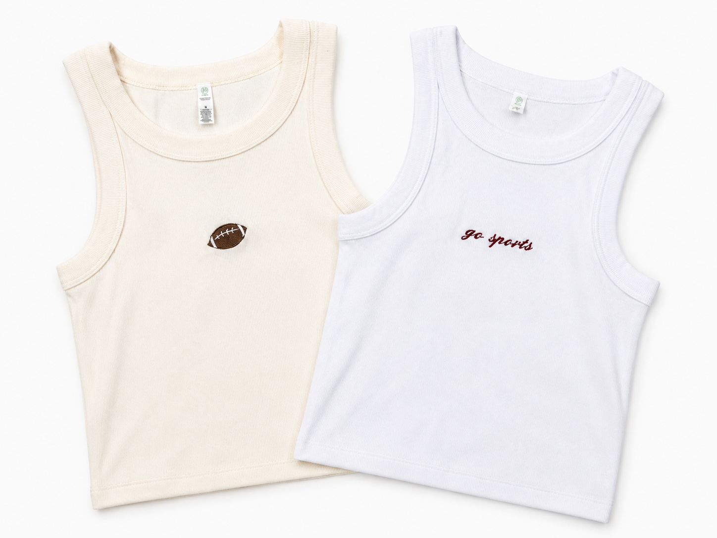 Two sleeveless tank tops laid flat on a white background: one cream with a small brown football patch on the chest, and one white with small red cursive text reading 'Go Sports' on the chest.