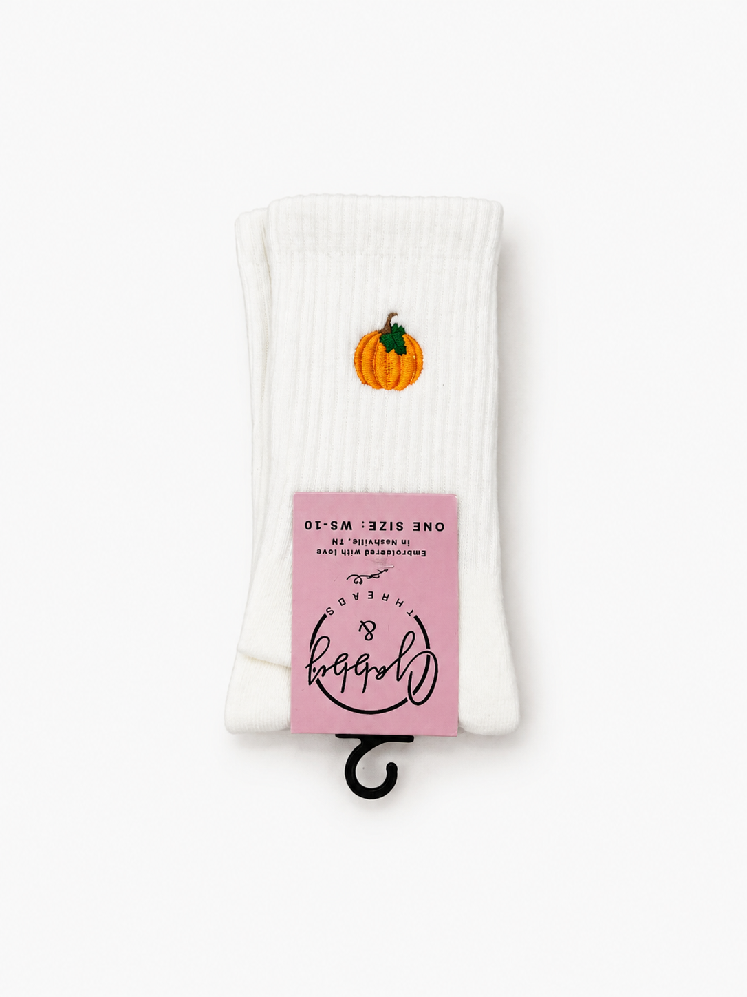a pair of white socks against a white background with an orange Halloween Pumpkin embroidered on it 