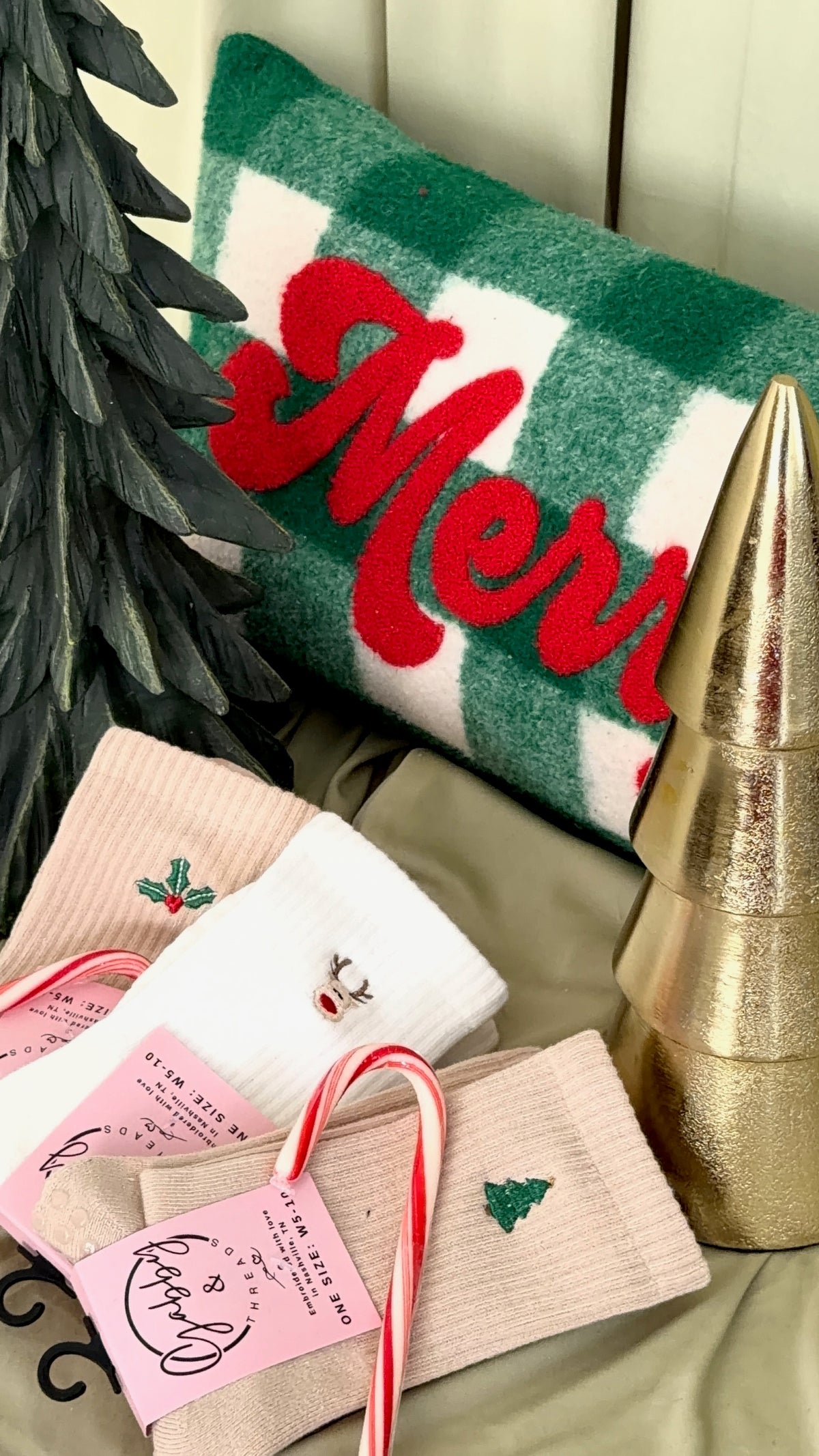 three pairs of socks featuring different christmas icons such as a holly sprig, reindeer, and christmas tree