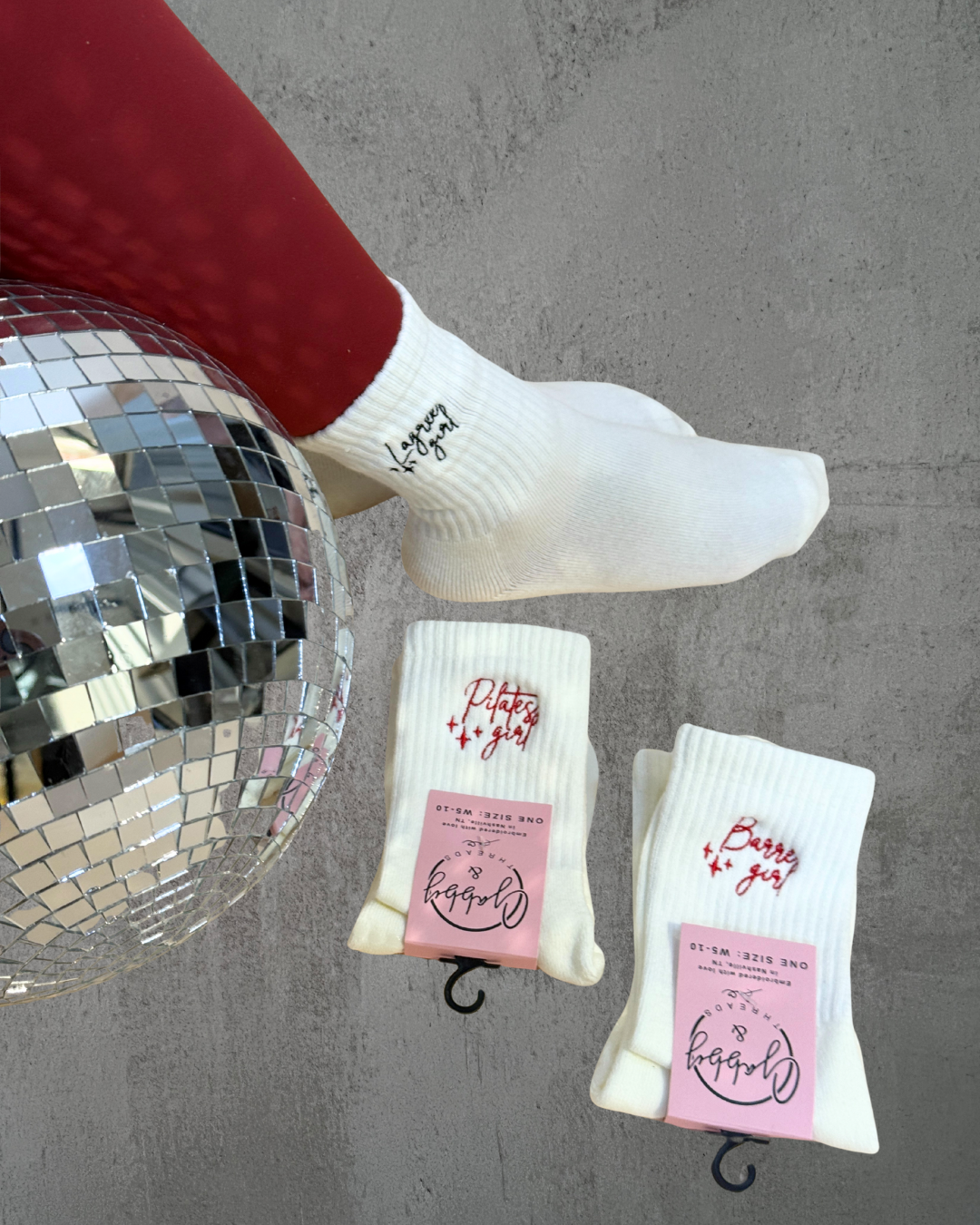three pairs of grip socks with embroidery on them next to a discoball
