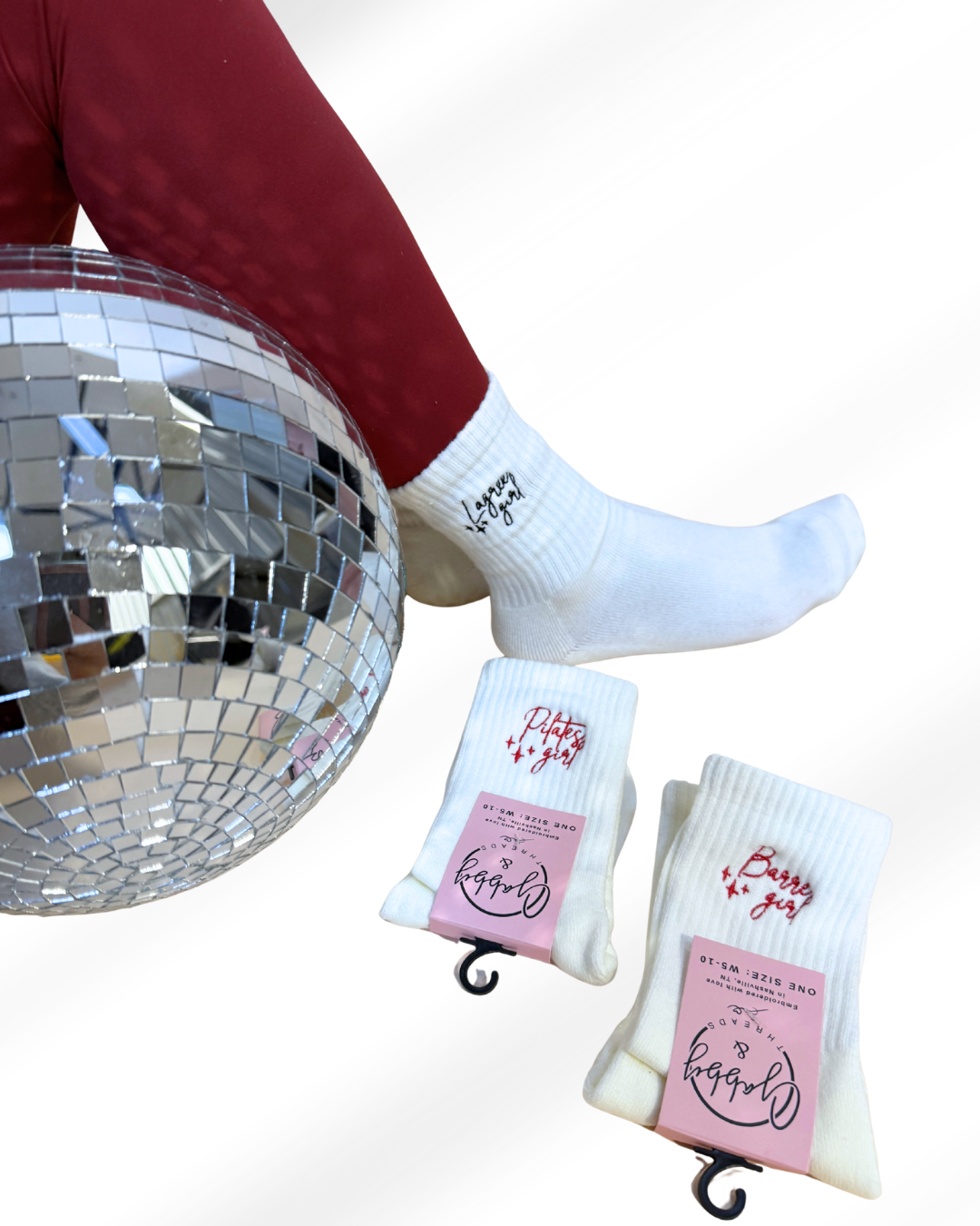 Person wearing white socks with pink packaging next to a disco ball on a white background