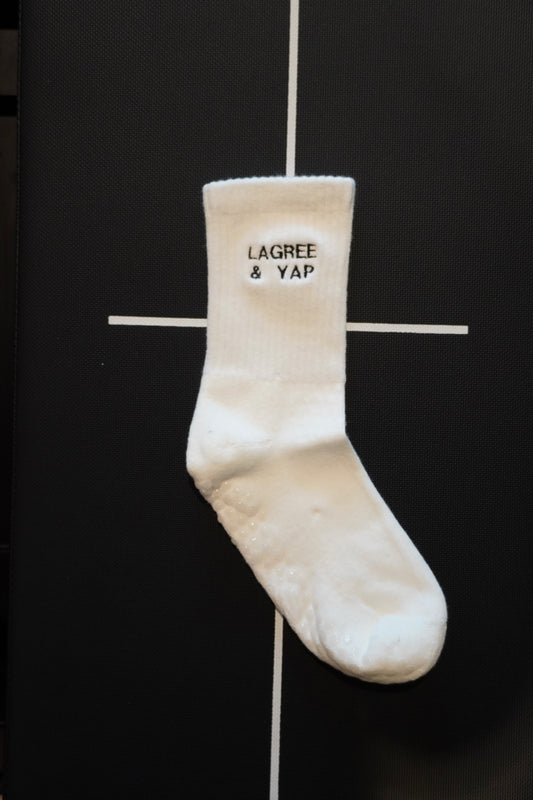 a pair of white grip socks with the text "Lagree & Yap" embroidered on them
