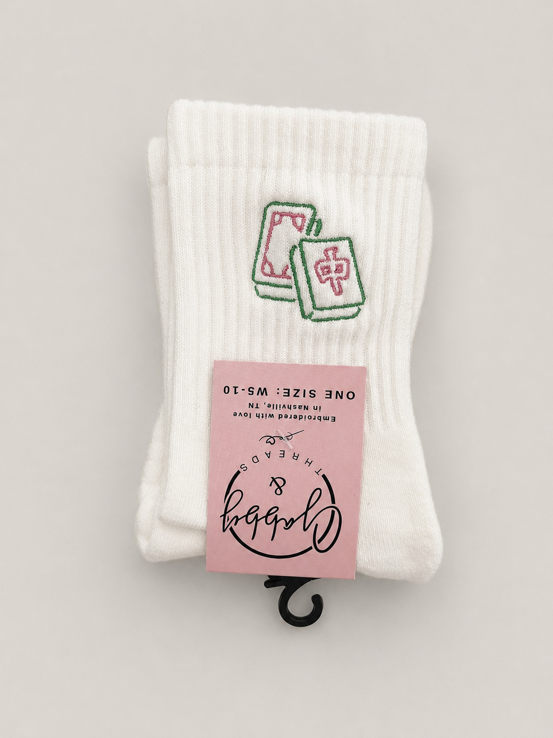 a pair of socks with mahjong tiles embroidered on them against a neutral background
