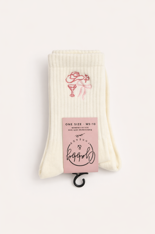 a pair of white grip socks with embroidered hat, coquette, bow and martini glass
