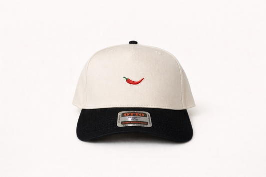 White and black cap with a red pepper design on a white background