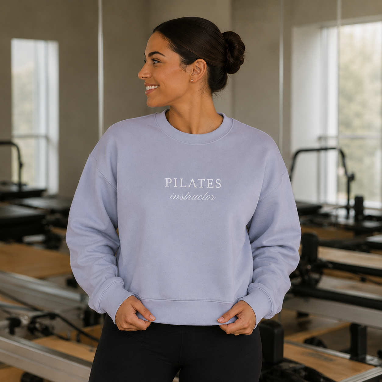 a woman is in a pilates studio wearing an embroidered crewneck that says pilates instructor on it