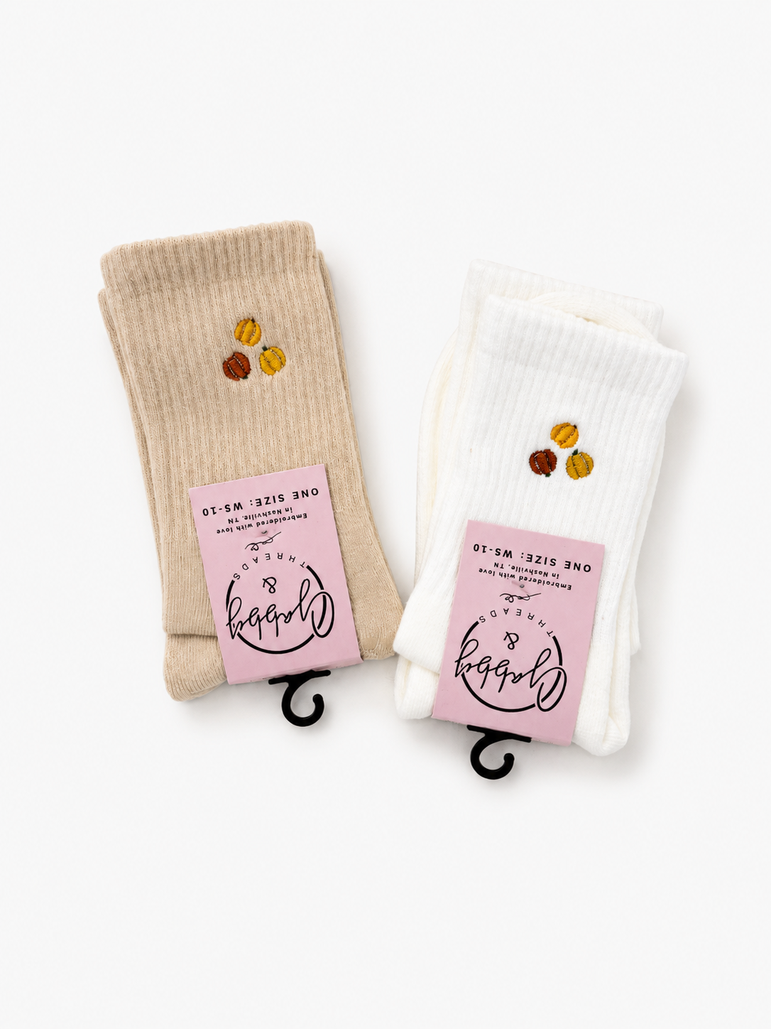 two pairs of socks with a three pumpkins embroidered on them