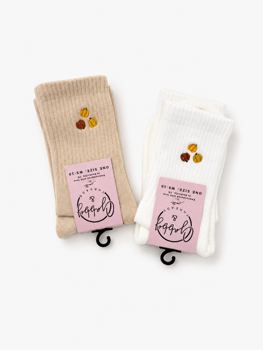 two pairs of socks with a three pumpkins embroidered on them