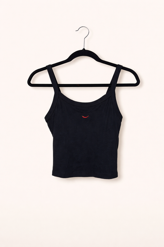 Black crop top on a hanger against a white background with a red pepper embroidered on it