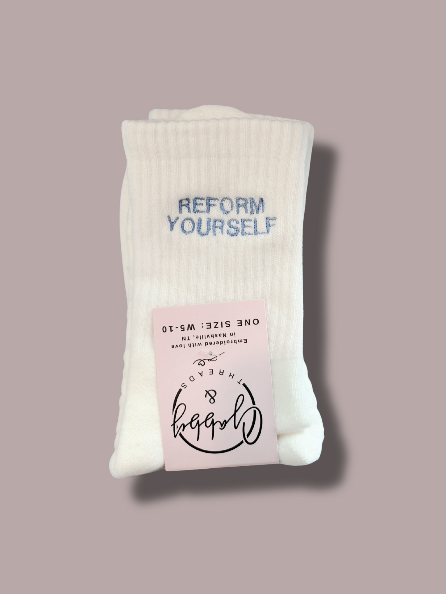 White grip socks with "REFORM YOURSELF" embroidered on them