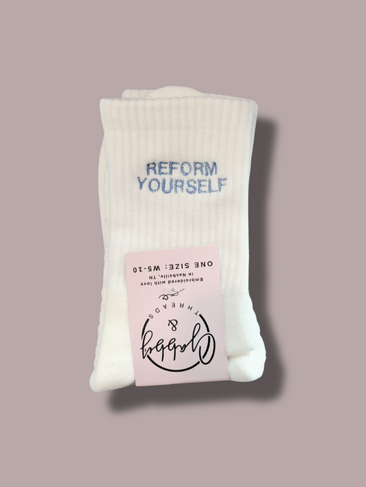 White grip socks with "REFORM YOURSELF" embroidered on them