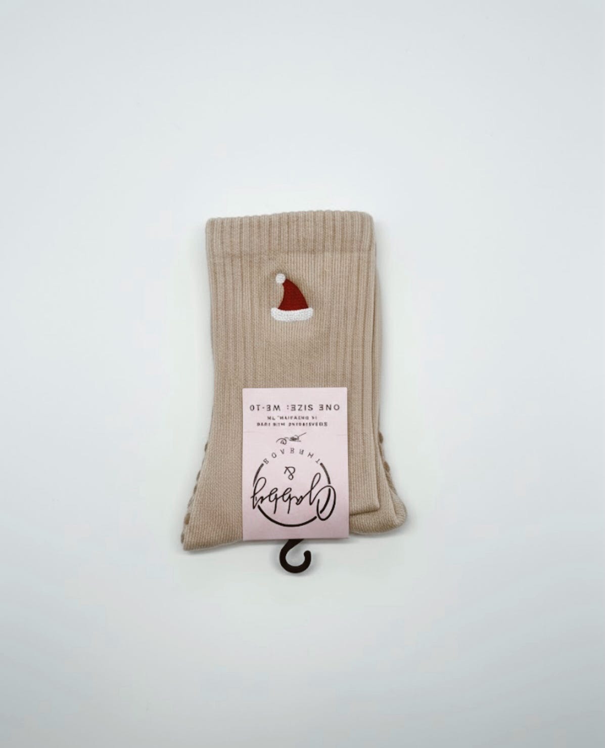 a pair of beige grip socks with an embroidered santa hat on them