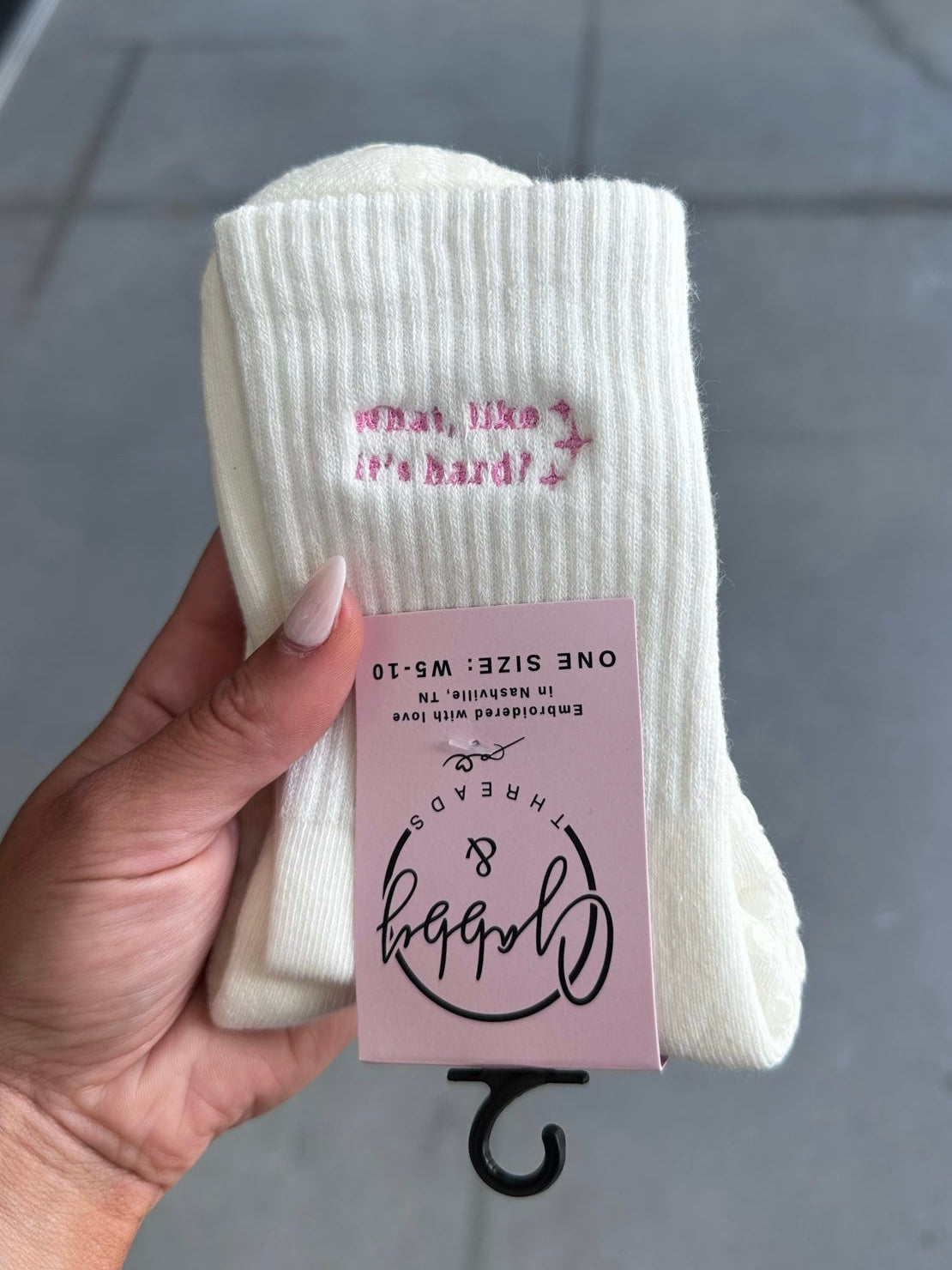 White grip socks with "What, like it's hard?" embroidered with sparkles