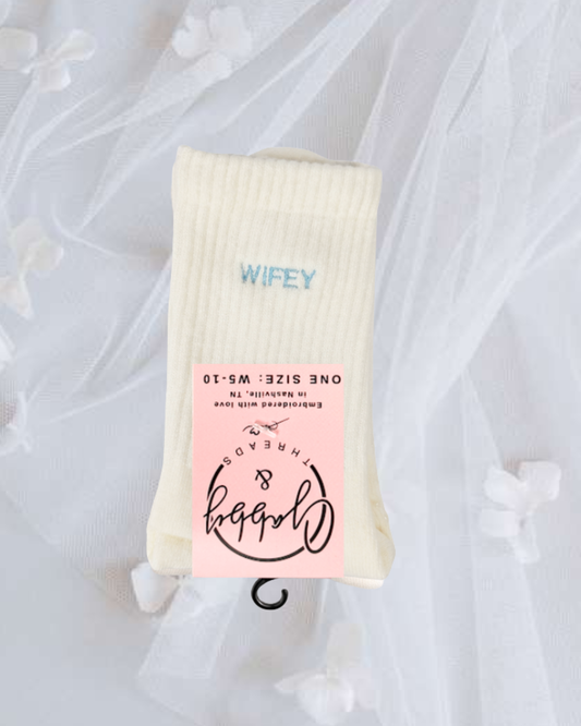 a pair of white grip socks with the word "wifey" embroidered on them